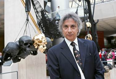 Brazilian artist Tunga poses in front of his sculpture A la lumiere des deux mondes displayed under the Louvre Museum's pyramid in Paris, 28 September 2005. Photo Thomas Coex via AFP/Getty Images.