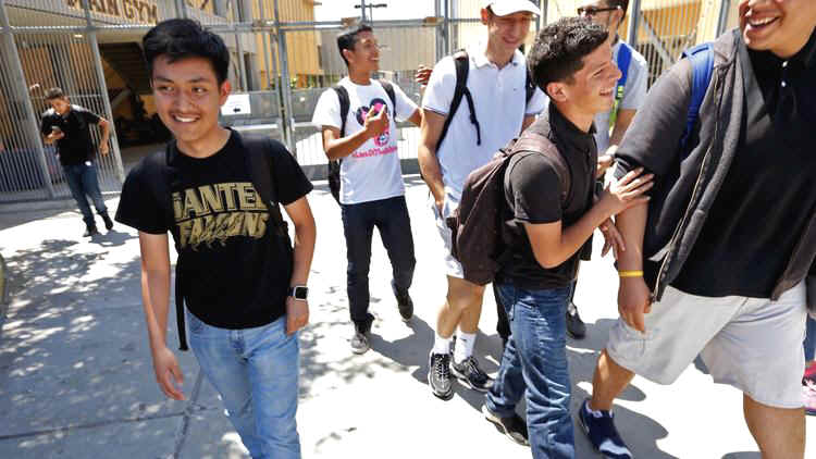 Noe Martinon, 18, left, walks through the campus of Santee Education Complex in Los Angeles.